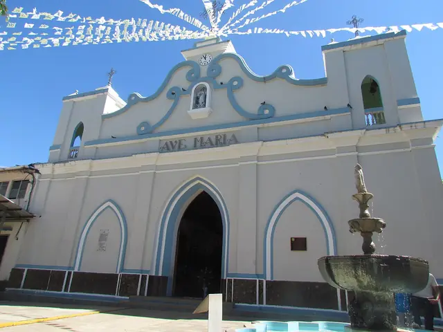The pale blue and white facade of Iglesia de la Inmaculada Concepción in Concepción de Ataco.