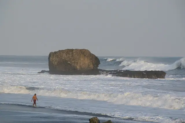 Waves breaking around the El Tunco rock formation.